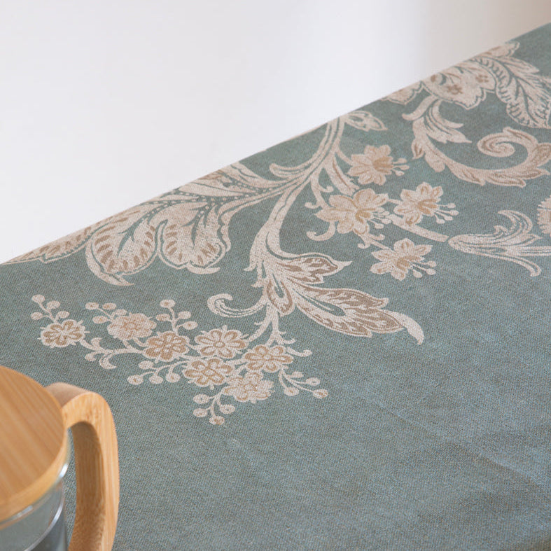 Floral patterned tablecloth in blue grey tones on a table with a white background