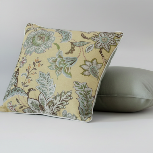 Floral-patterned yellow pillow and a plain light green pillow of 50x50 cm