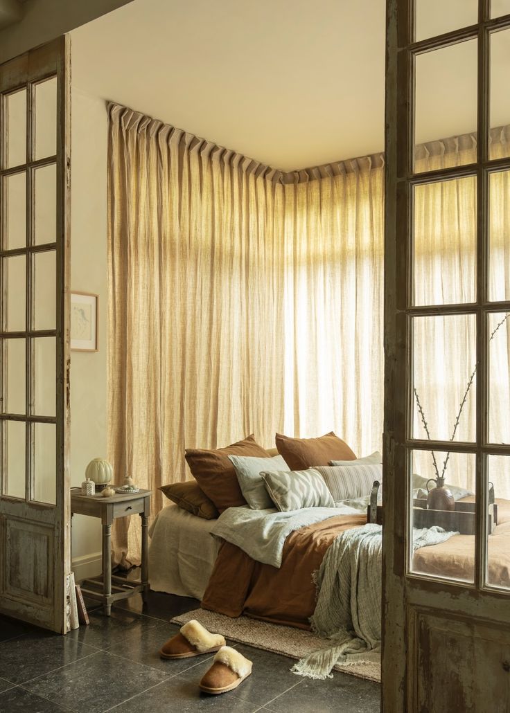 Cozy bedroom with a bed, pillows Linen & Grace, and a side table with a lamp. Ethno designs, Eclectic design, Boho geographical design