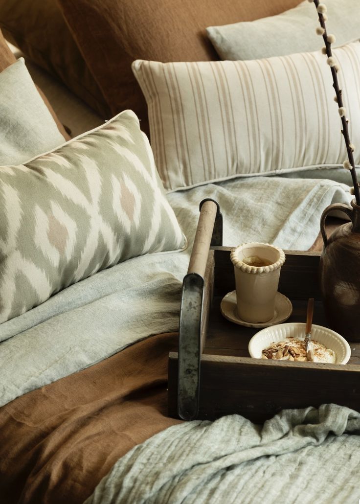 Tray with a cup and bowl on a couch with patterned cushions; Ethno style; Eclectic design