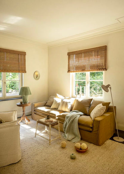 Cozy living room with beige sofa, wicker windows, and decorative cushions; Linen & Grace; Ethno Style; Eclectic design ; Boho