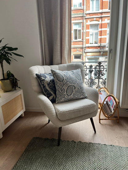 Blue-and-white patterned cushions on a classic armchair, blending modern flair with everyday comfort.