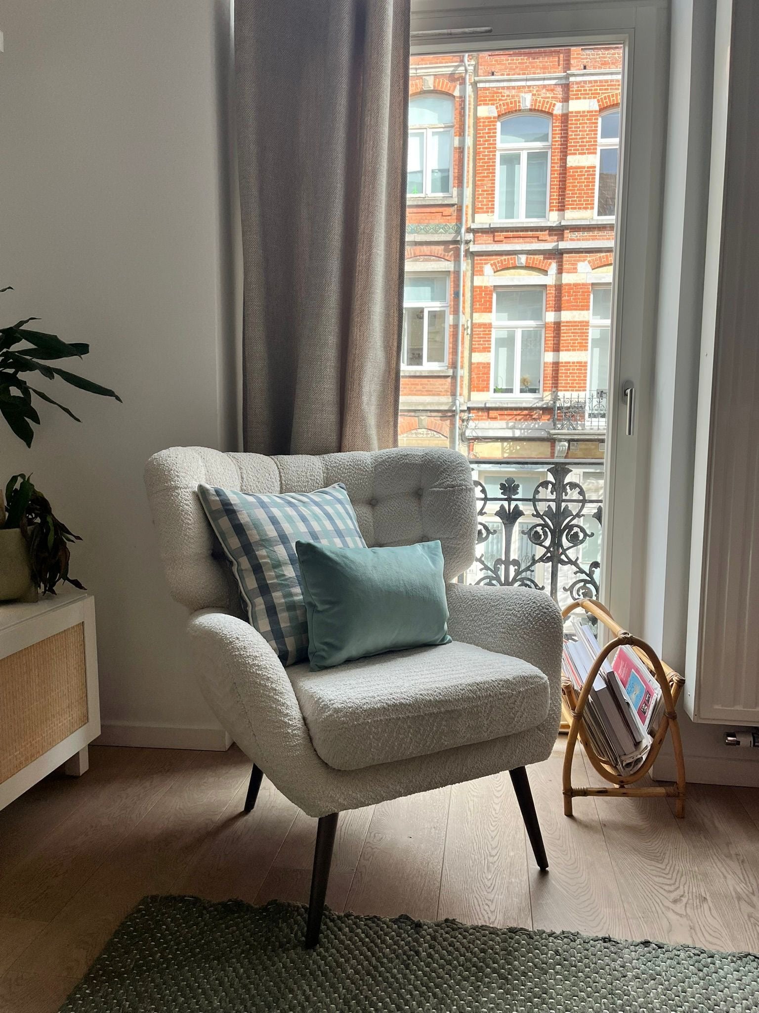 Armchair with checked cushions paired with an elegant velvet aqua blue cushion for a rich, layered look