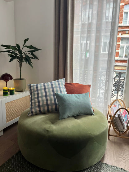 Green bean bag chair with colorful cushions in a living room setting.