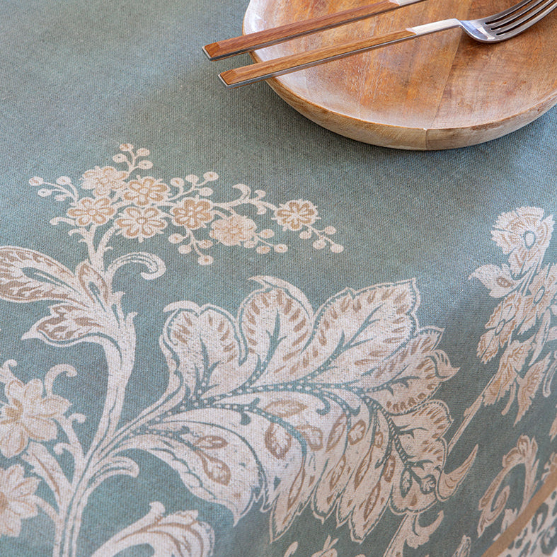 Wooden plate with cutlery on a floral-patterned tablecloth