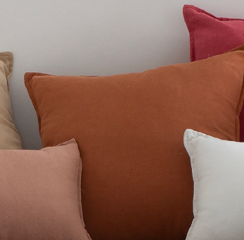 Close-up of various colored pillows on a neutral background