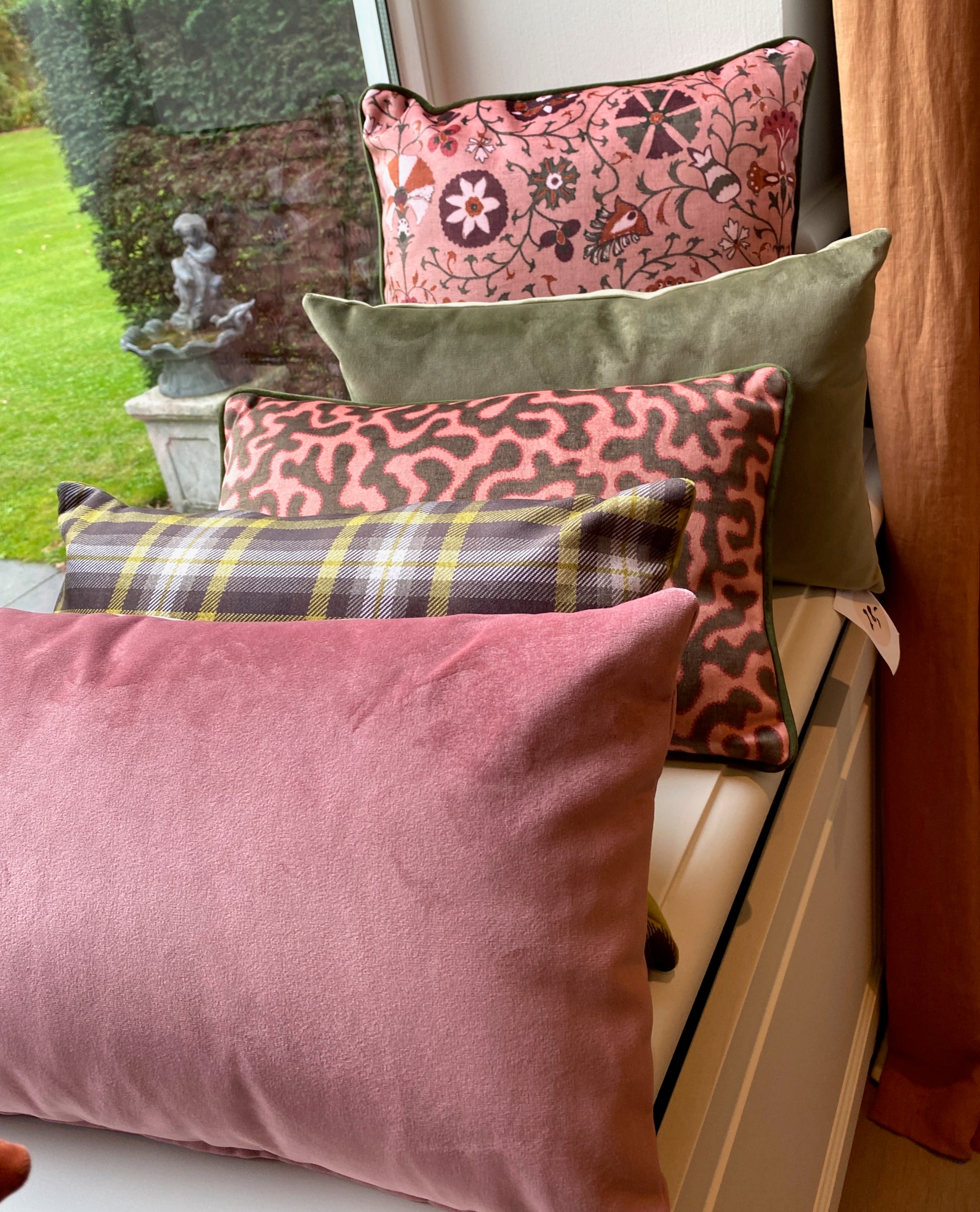 Colorful patterned cushions on a bench outdoors.